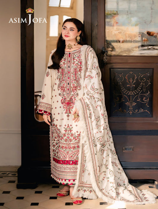 Woman in a white and red embroidered traditional outfit standing indoors, with 'Asim Jofa' branding visible.
