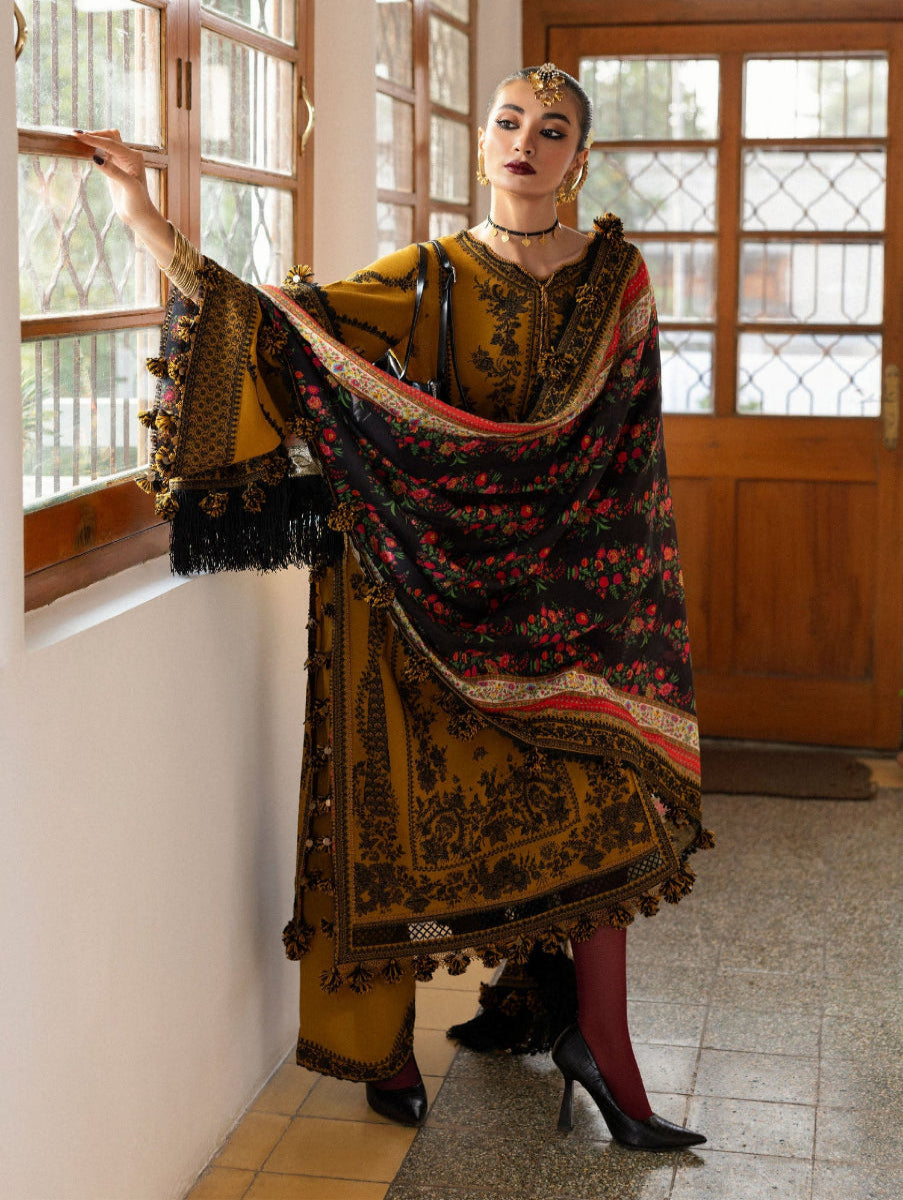 Woman in traditional outfit with a floral shawl in a room with wooden doors and windows.