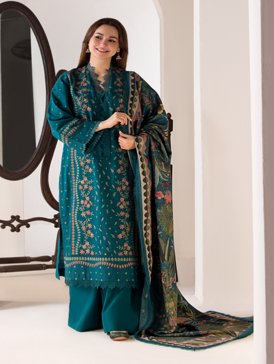 Woman wearing a teal embroidered outfit with a matching dupatta in a minimalistic setting.