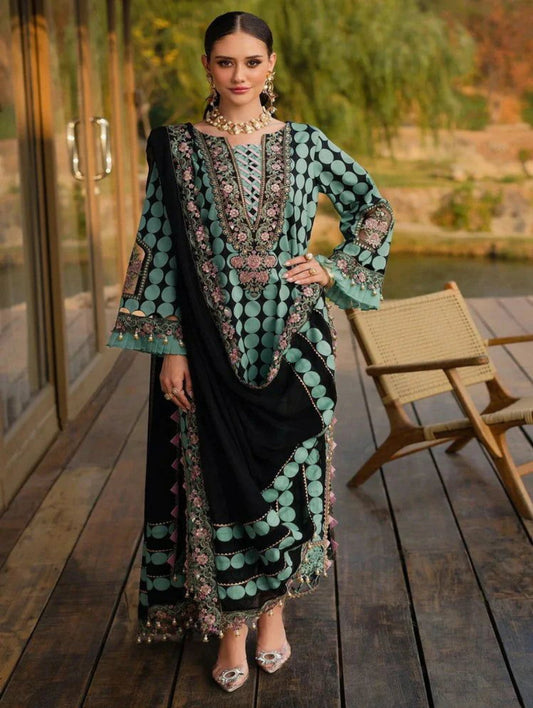 Woman in a traditional outfit with intricate patterns standing on a wooden deck.