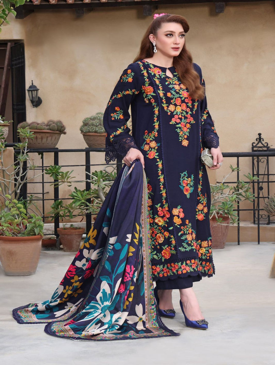 Woman wearing a dark blue embroidered dress with colorful floral patterns outdoors.
