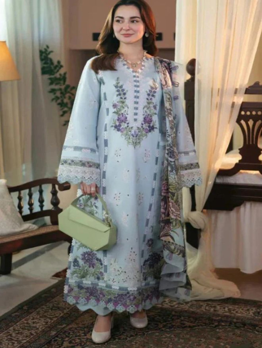 Woman in a floral dress standing in a decorated room with curtains and furniture.